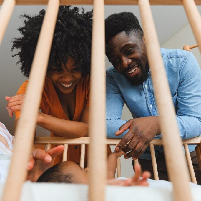 a couple looking at a baby in a crib
