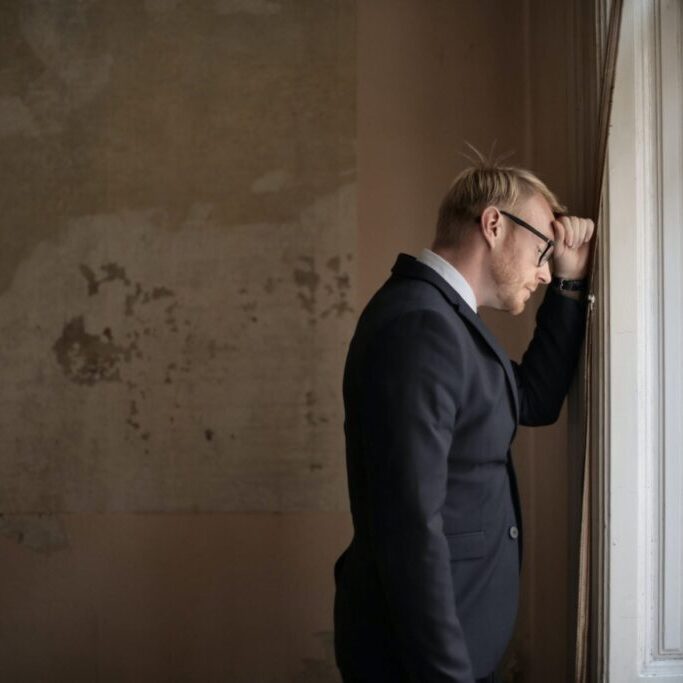 grieving individual standing near window